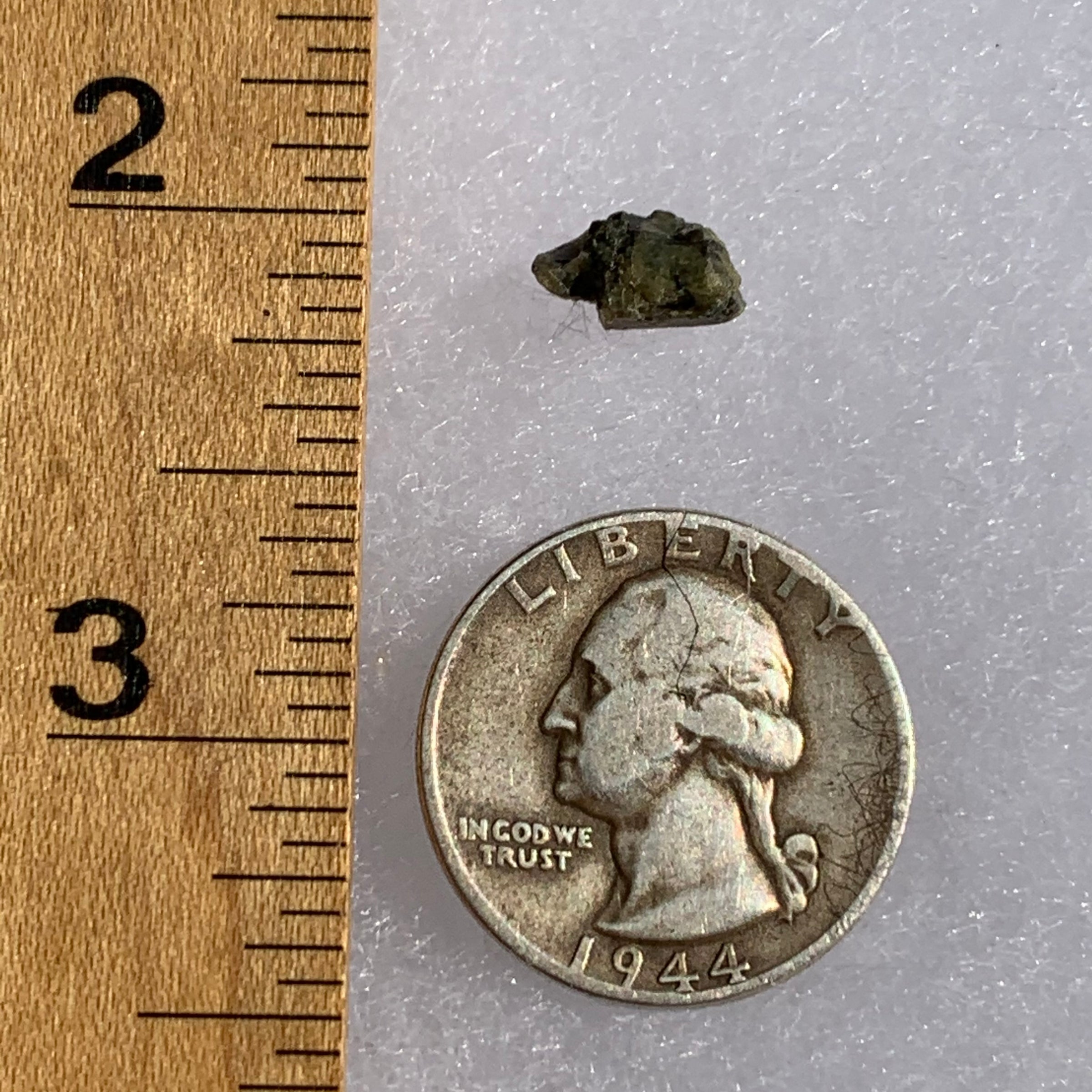 tatahouine meteorite next to a ruler and US quarter for scale