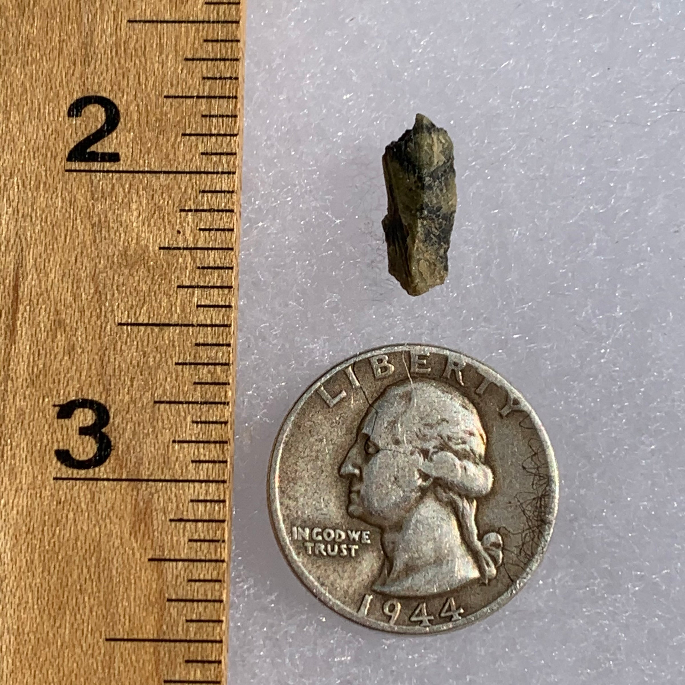 tatahouine meteorite next to a ruler and US quarter for scale